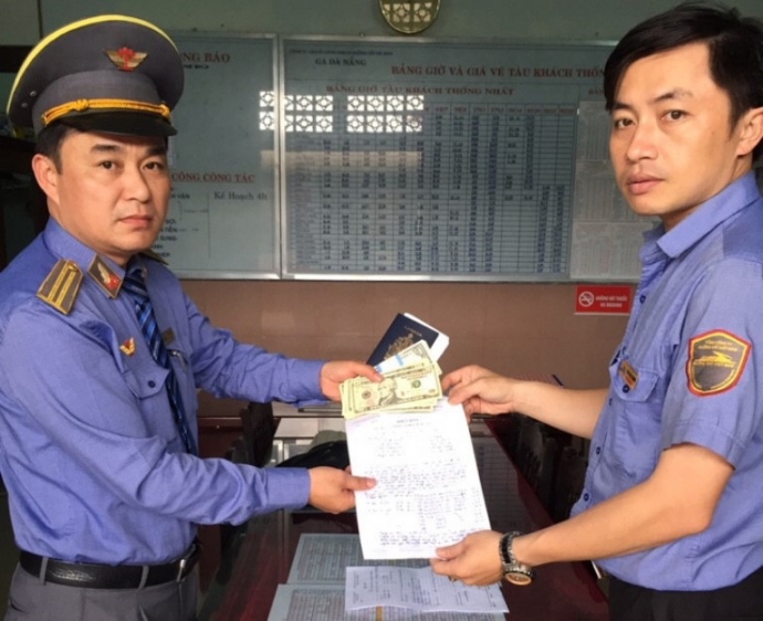 Trưởng tàu SE3 Vũ Thanh Minh (trái) bàn giao 1.200 USD cho đại diện ga Đà Nẵng
